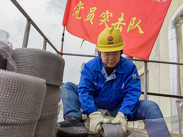 5月10日中午，在動(dòng)力車間三期工藝除氧器平臺(tái)上，黨員突擊隊(duì)隊(duì)長(zhǎng)李鑫正在纏繞新填料.jpg